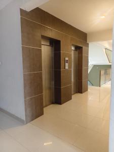 a hallway with two elevators in a building at Govindha bhavanam 150 meters from Guruvayur temple in Guruvāyūr