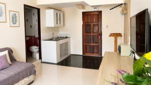 a living room with a couch and a kitchen at Fortune Pattaya Resort in Jomtien Beach