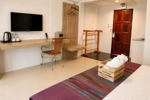 a room with a desk and a tv on a wall at Fortune Pattaya Resort in Jomtien Beach