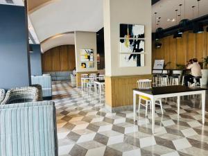 a restaurant with a checkered floor and tables and chairs at Hotel The Grace Residency - Near Hotel Hyatt ,DLF MyPad, Gomtinagar, Lucknow in Lucknow