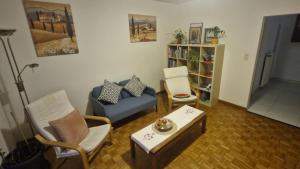 a living room with a blue couch and chairs at Alpine Apartment in Villeneuve