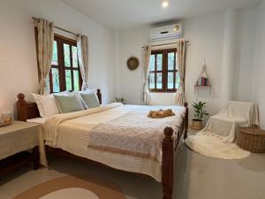 a bedroom with a large bed with shoes on it at Thong Sala Japandi Villa in Thong Sala