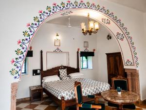 a bedroom with a bed with an arch above it at Alivaa Heritage Lotwara Fort - Near Shri Mehandipur Balaji Temple in Dausa