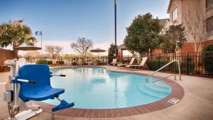 una silla azul sentada junto a una piscina en Best Western Plus Executive Hotel & Suites, en Sulphur