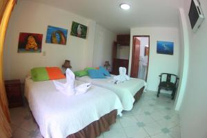 two beds in a room with two white beds at The Island Home in Puerto Ayora