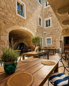 a patio with tables and chairs and a brick wall at Hotel Heritage Casa Blanka in Makarska