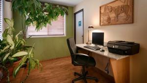 biuro z biurkiem z komputerem i krzesłem w obiekcie Oakridge Inn & Suites w mieście Oakridge