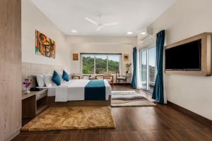 a bedroom with a bed and a large window at Nivaara by GHD Hotels in Nerul