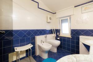 a blue tiled bathroom with a toilet and a sink at Appartamento Maison Sabrina con vista giardino in Borgofranco dʼIvrea +29 photos