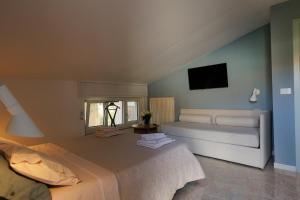 a bedroom with a bed and a tv on the wall at Appartamento Maison Sabrina con vista giardino in Borgofranco dʼIvrea