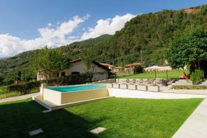 a yard with a swimming pool and a house at Appartamento Maison Sabrina con vista giardino in Borgofranco dʼIvrea