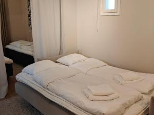 a bed with white sheets and towels on it at Metsäniitty in Kempele