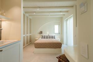 a white bedroom with a bed and a sink at Naxia Gaia Suites in Agia Anna Naxos