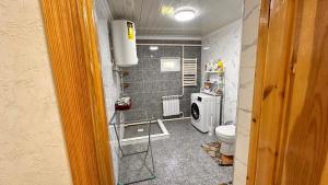 a small bathroom with a toilet and a washing machine at NomadicaKyrgyz in Tërt-Kul'