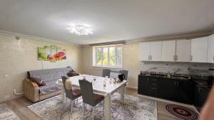 a kitchen and a living room with a table and chairs at NomadicaKyrgyz in Tërt-Kul'