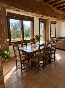 a dining room with a wooden table and chairs at Gîtes les Deux Vallées in Le Bois-Hellain
