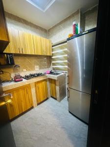 a kitchen with a stainless steel refrigerator and wooden cabinets at April shortlet apartments in Lagos