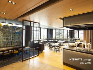 a restaurant with tables and chairs in a building at Hotel Intergate Osaka Umeda in Osaka