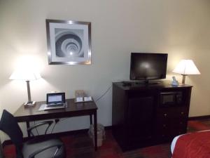 a hotel room with a desk with a laptop and a television at Best Western Springfield West Inn in West Springfield