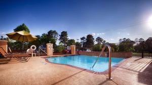 a swimming pool with a slide and an umbrella at Best Western Longview in Longview
