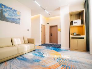 a living room with a couch and a kitchen at Zenn Hotel Erdenet in Erdenet