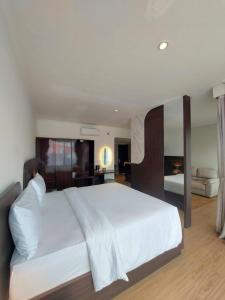 a bedroom with a large white bed in a room at Hotel Imam Bonjol by Benhas in Padang +12 photos