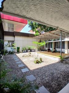 a building with a garden in front of it at Hotel Imam Bonjol by Benhas in Padang