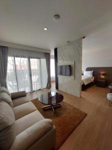 a living room with a couch and a table at Hotel Imam Bonjol by Benhas in Padang
