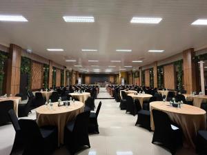 a row of tables and chairs in a banquet hall at Hotel Imam Bonjol by Benhas in Padang