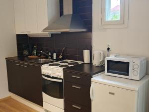 a small kitchen with a stove and a microwave at Metsäniitty in Kempele +10 photos