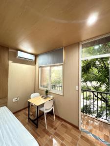 a bedroom with a table and a bed and a balcony at Linh's House in Danang +29 photos