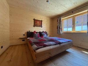a bedroom with a bed in a log cabin at Ferienhof Winkler in Bernbeuren