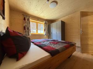 a bedroom with a bed in a wooden cabin at Ferienhof Winkler in Bernbeuren