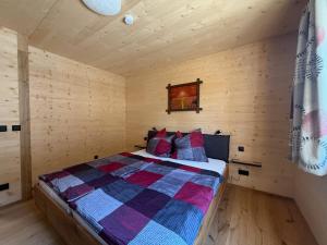 a bedroom with a bed in a wooden cabin at Ferienhof Winkler in Bernbeuren
