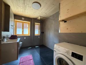 a laundry room with a washer and a sink at Ferienhof Winkler in Bernbeuren +18 photos