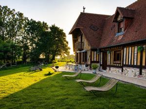 a group of benches sitting in the grass in front of a building at Gîtes les Deux Vallées in Le Bois-Hellain