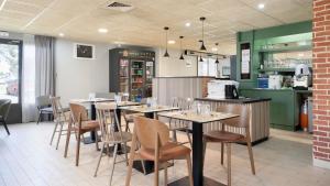 a dining room with tables and chairs in a restaurant at Campanile NATURE - Mont de Marsan in Mont-de-Marsan