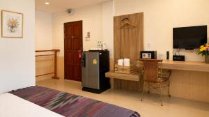 a room with a refrigerator and a desk with a computer at Fortune Pattaya Resort in Jomtien Beach +17 photos