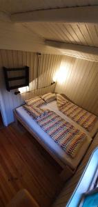 a bed in a wooden room with a wooden floor at Sona Camping in Hegra