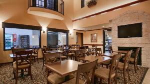 um restaurante com mesas e cadeiras e uma lareira em Best Western Alamo Suites Downtown em San Antonio