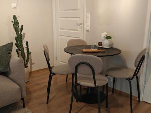 a table with four chairs and a table with a vase at Metsäniitty in Kempele