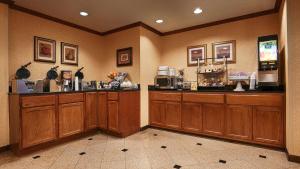 a restaurant with wooden cabinets and a food counter at Best Western Alamo Suites Downtown in San Antonio