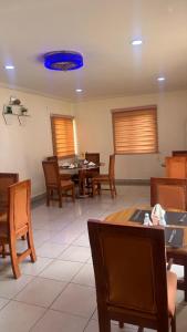 a dining room with tables and chairs and a blue ceiling at NBTE Hotels in Kaduna
