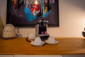 a coffee maker and cups on a wooden table at Waterl'O in Waterloo