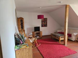 a living room with a red rug and a bedroom at idyllisches Mühlengebäude in Hillesheim