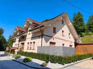 a house with a fence in front of it at Apartment Cankar's View in Vrhnika
