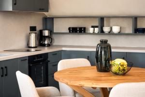 a kitchen with a wooden table with chairs and a bottle at Luminosa Collection - Casa Celeste in Razáta