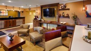 un ampio soggiorno con TV, tavolo e sedie di Best Western Gateway Inn a Yazoo City
