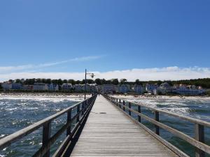 a wooden pier stretches out into the water on a beach at Bansin, Aquamarina WG 10 in Bansin