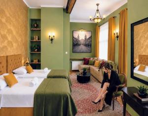 a woman sitting in a room with two beds at Otium Old Town Boutique in Krakow